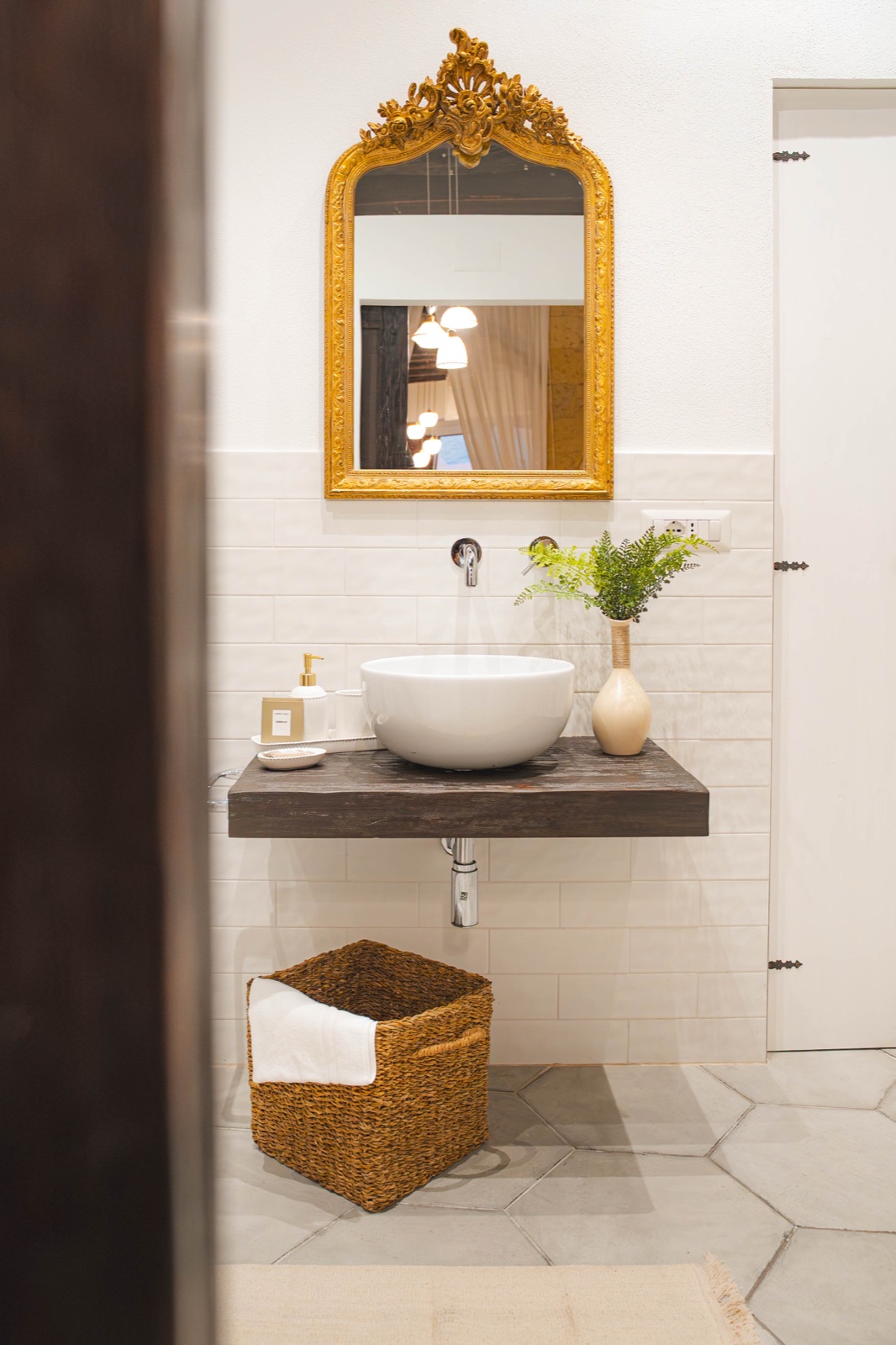 Bagno con specchio dorato e lavabo d'appoggio